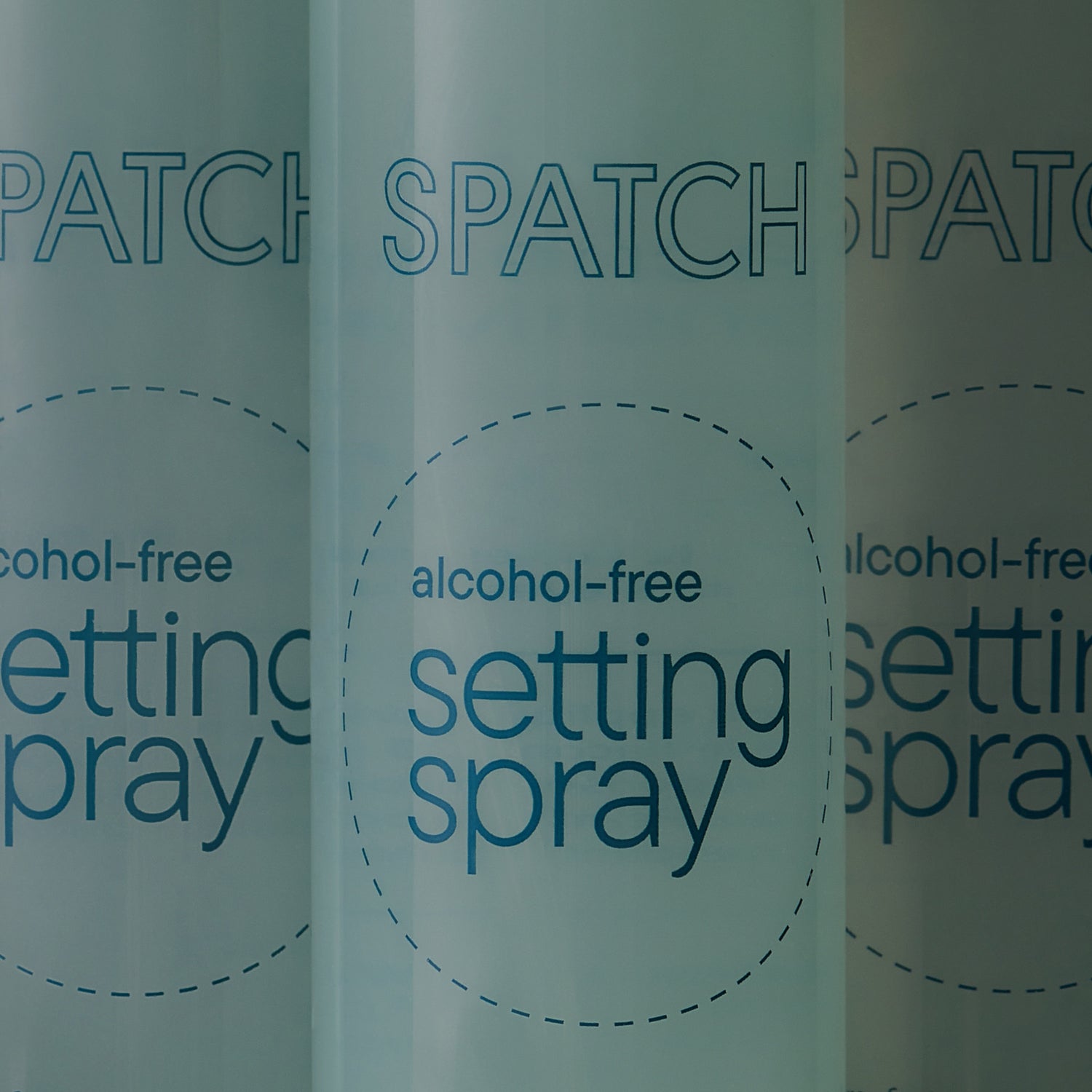 Closeup photo of three bottles of aqua-colored makeup setting spray with the words "SPATCH alcohol-free setting spray" on the bottles